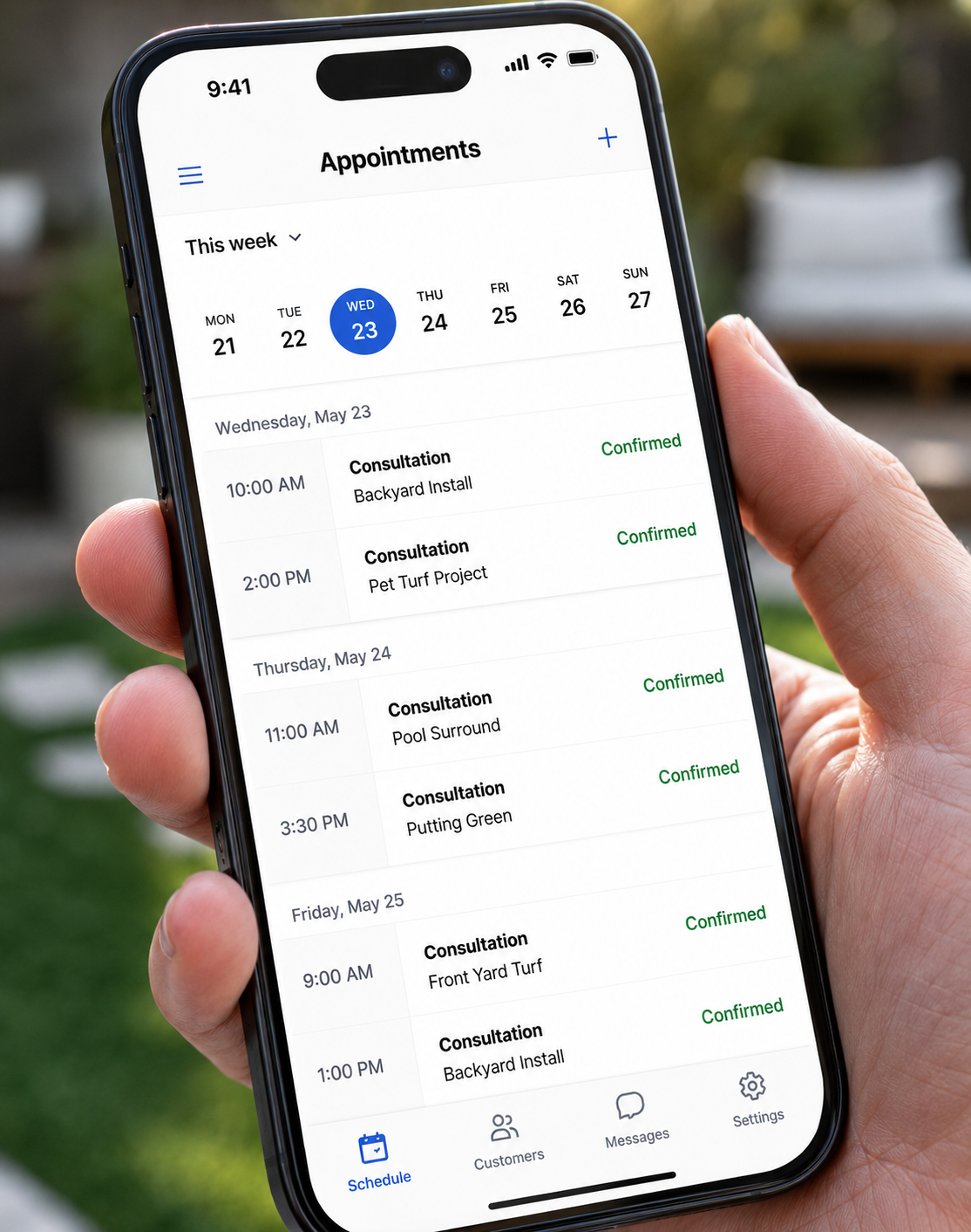 Installer holding a phone showing a calendar full of booked consultations